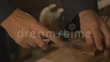 木工师傅在车间用铅笔、绘图、手工工具在木板上做铸造。